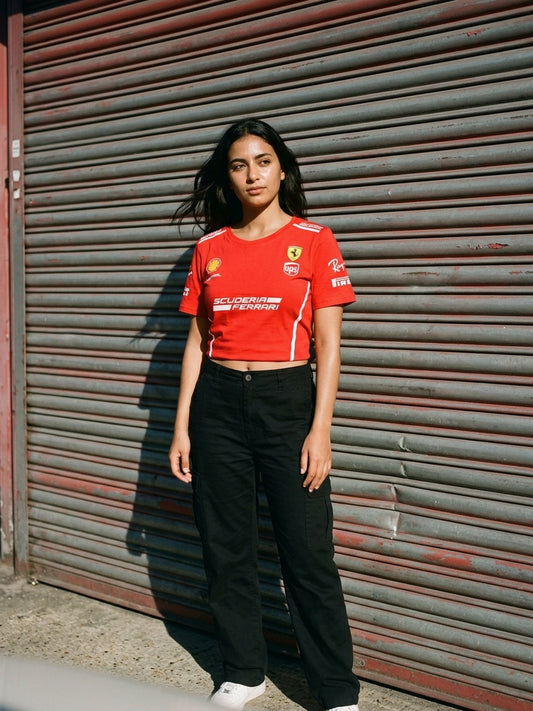 Newtral Ferrari Scuderia women's crop tee in red, model standing in front of a red roller shutter